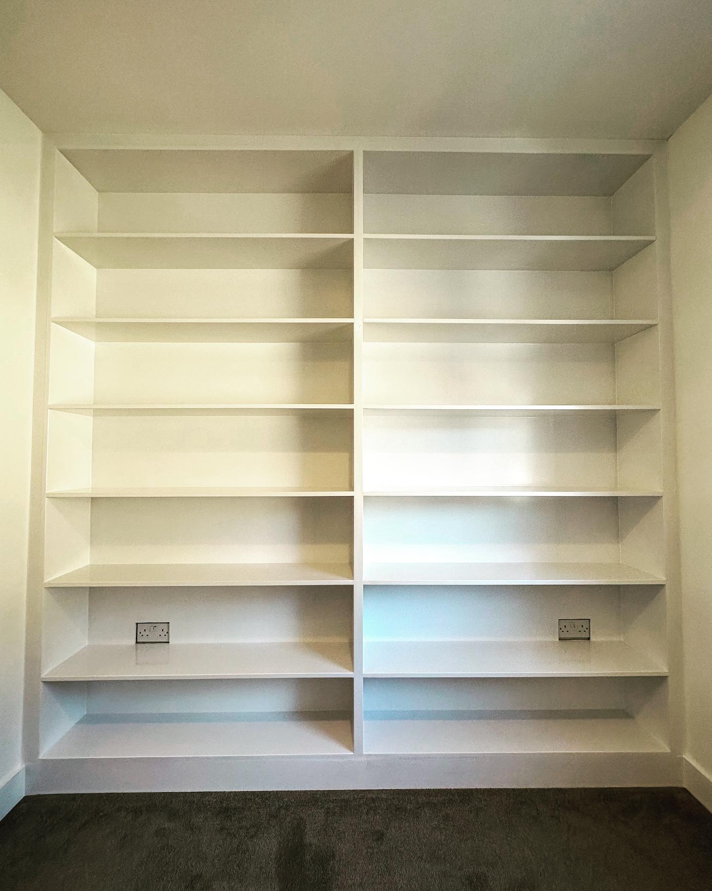 Floor to ceiling built-in white alcove shelving