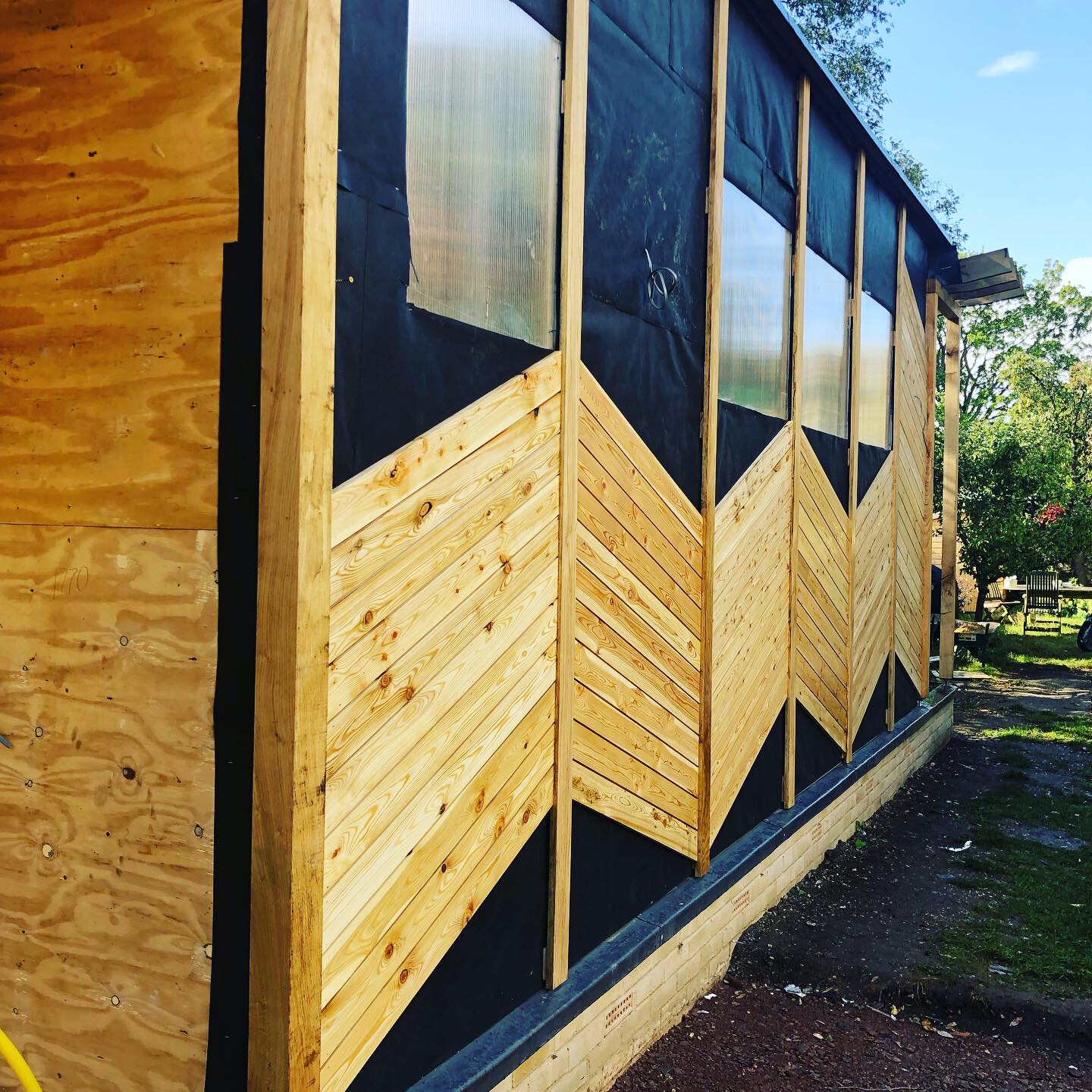 Timber cladding laid in a chevron pattern on an outdoor building